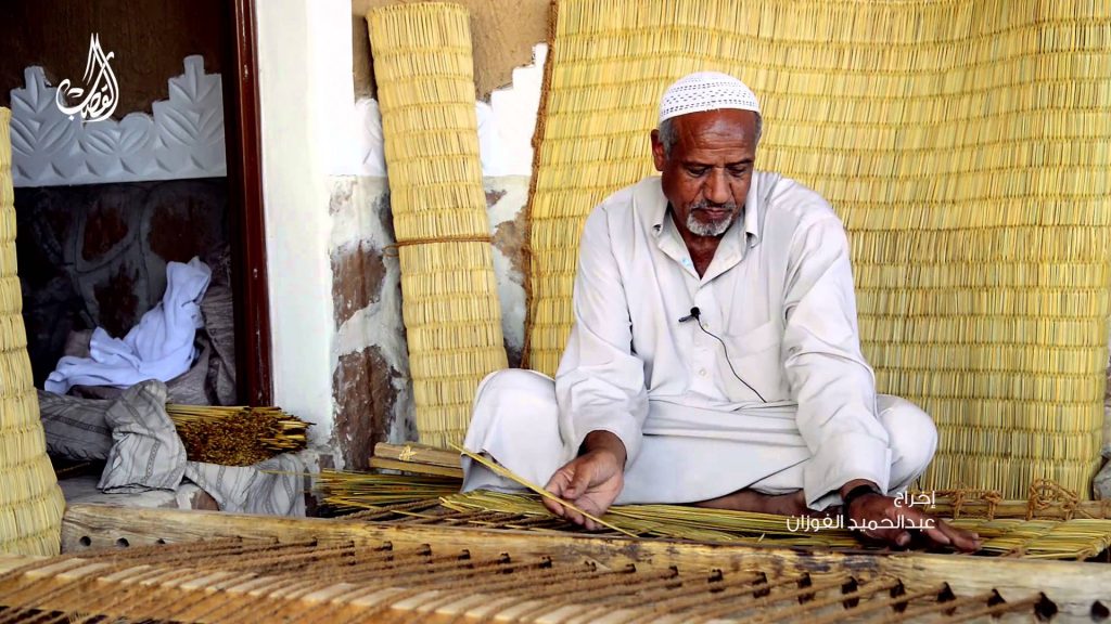 Craftsman weaves mat on loom. Photo credit: https://i.ytimg.com/vi/eFR348OyzP8/maxresdefault.jpg