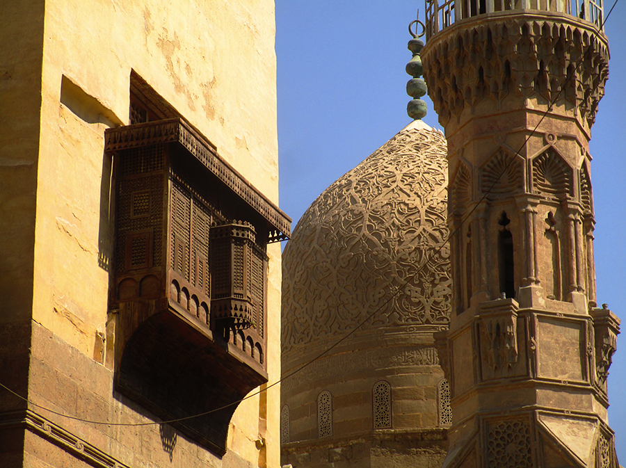 Mashrabiyya (wooden lattice screens) with a typical Mameluk mosque in the background