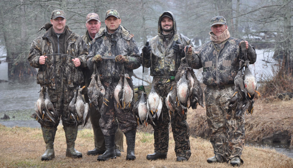 A grou of hunters osing with their hunted ducks courtesy beaverdamducks.com