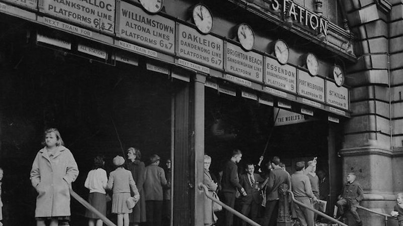 People wait under the clocks at Flinders Street Station in 1963. Photo credit: HWT Image Library