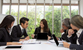 Team of asian business posing in meeting room. Working brainstorming on the table in a room. asian people. The office. presentation with computer. Group young colleagues using laptop at office.