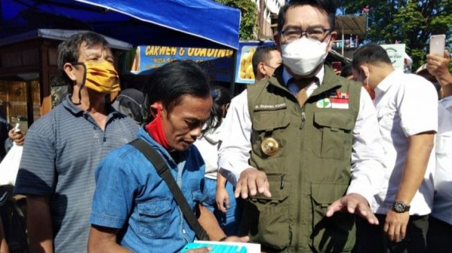 Gubernur Jawa Barat (Jabar) M Ridwan Kamil atau Kang Emil memberikan hadiah berupa telepon pinter untuk Ade Lombok, seorang warga yang mendadak viral seusai mempromosikan makanan Odading Mang Oleh dengan gaya "ngegasnya", di Jalan Barangsiang Kota Bandung, Rabu (16/9/2020). (ANTARA/Dok Humas Pemprov Jabar)