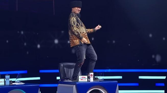 Ahmad Dhani naik meja juri Indonesian Idol saat Mulan bernyanyi. [YouTube/Indonesian Idol]