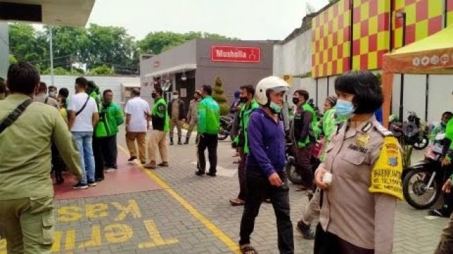 Petugas memberikan imbauan di McDonald's di Jalan Sisingamangaraja Medan. [Suara.com/M Aribowo]