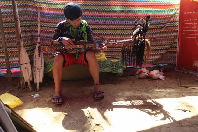 A member of the Lumad group plays the 'kudyapi,' a two-stringed musical instrument created by particular tribal groups in Mindanao. Photo by Bernard Testa, InterAksyon.com.