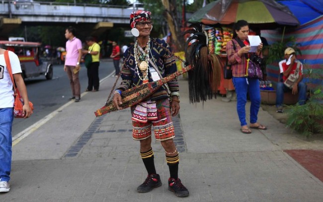 A Lumad elder dressed in traditional attire takes a break after performing some traditional songs with his 'kudyapi.' Photo by Bernard Testa, InterAksyon.com. 