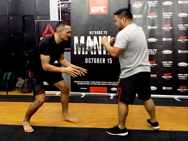 Max Holloway demonstrates “sprawl,” a defensive technique he uses in fights during a media event at SM Mall of Asia. Photo by Romsanne Ortiguero, InterAksyon.