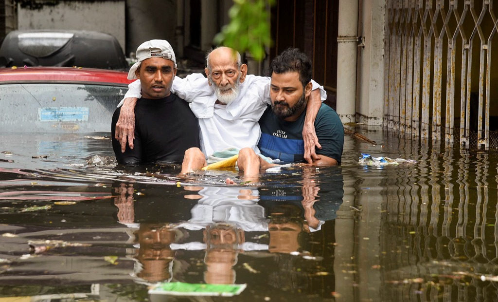 پٹنہ کے راجیندرنگر علاقے سے ایک بزرگ کو سیلاب متاثر ہ علاقے سے نکالتےلوگ۔ (فوٹو : پی ٹی آئی)