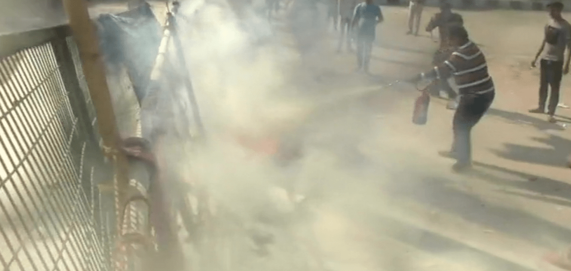 پٹرول بم سے لگی آگ بجھانے کی کوشش کرتا ایک شخص (فوٹو: اے این آئی)