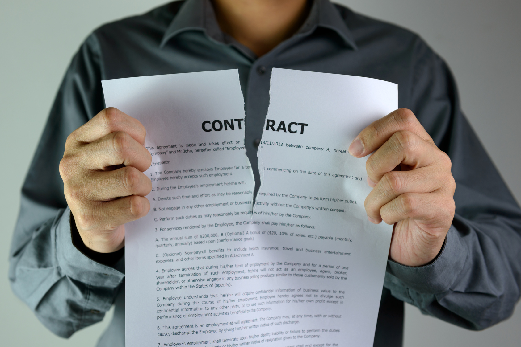 Businessman ripping a contract down to the centre