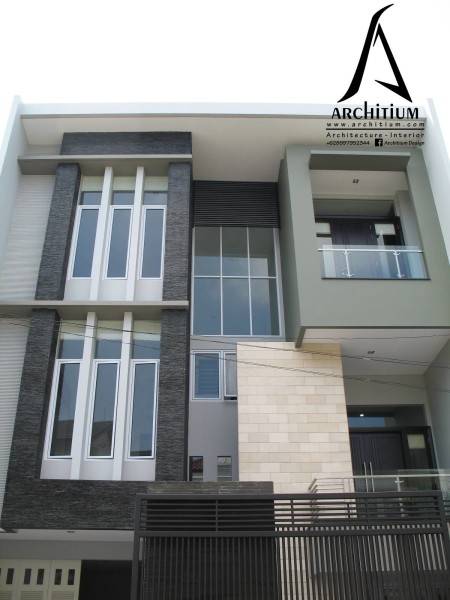 Tampak depan rumah minimalis dengan material batu alam teknik rata mesin (warna krem) House at Kelapa Gading karya Architium Design [Sumber: arsitag.com]