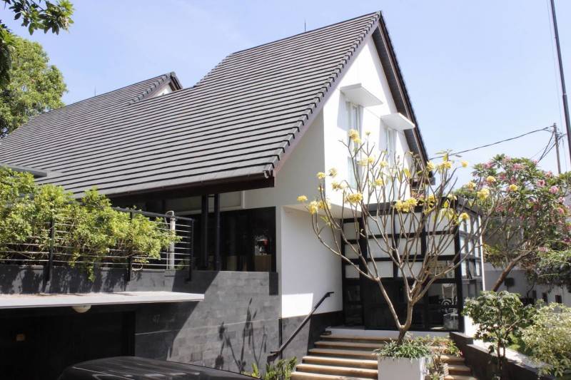 Material batu alam teknik rata bakar pada tampak depan rumah minimalis Cijantung House karya Monokroma Architect [Sumber: arsitag.com]