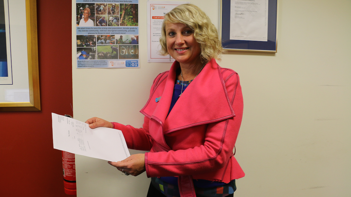 Helen Campbell shows a patient receipt that displays giving contribution