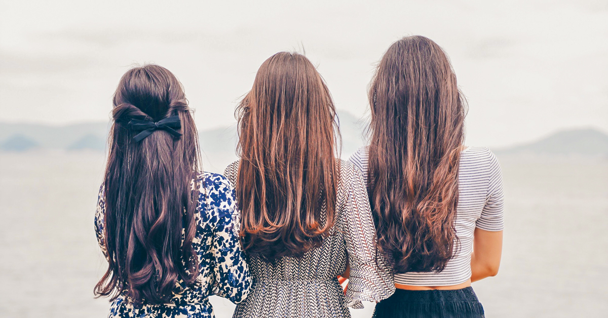 back view of three long-haired women