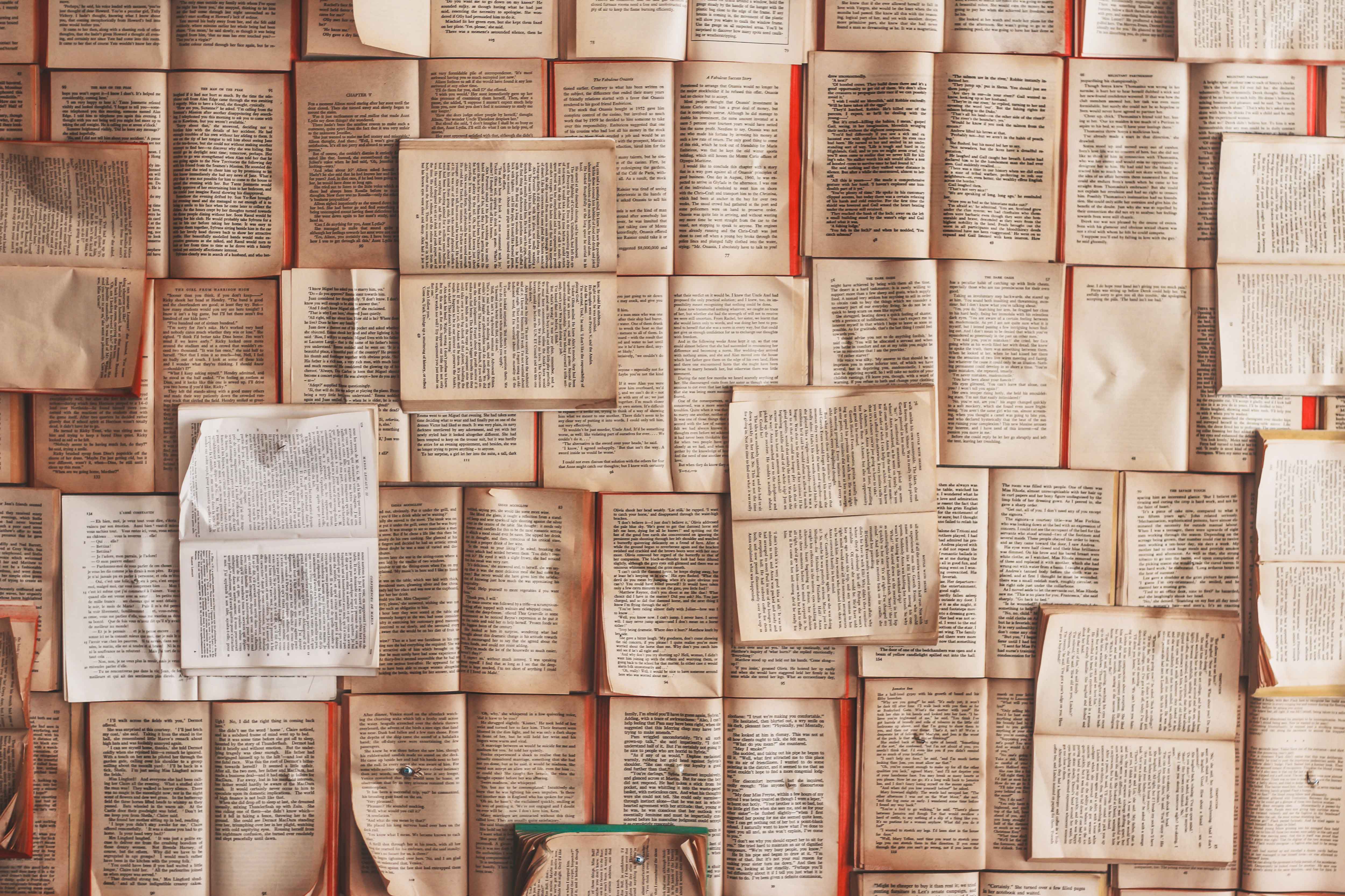 many open books neatly laid out on a table, filling up the whole photo
