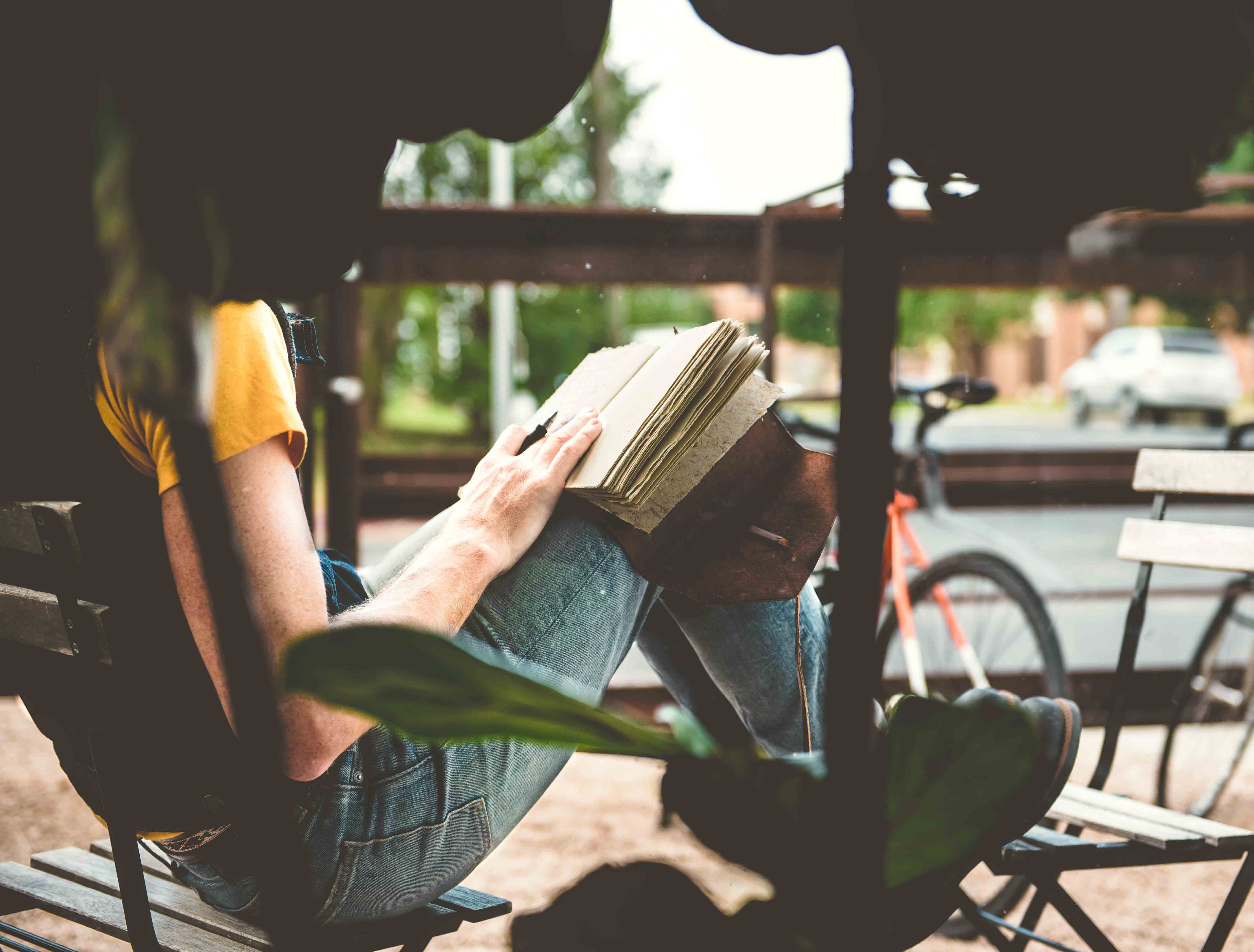 girl writing on a notebook while sitting in a porch