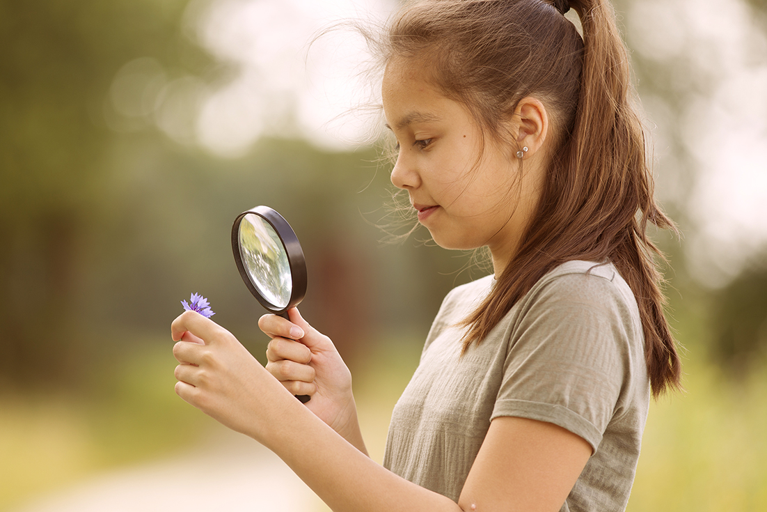 girl examining a microscope