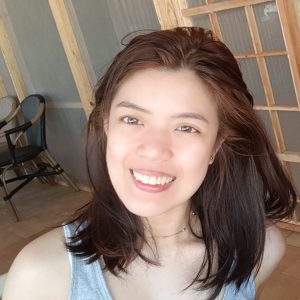 girl with shoulder-length dark brown hair smiling