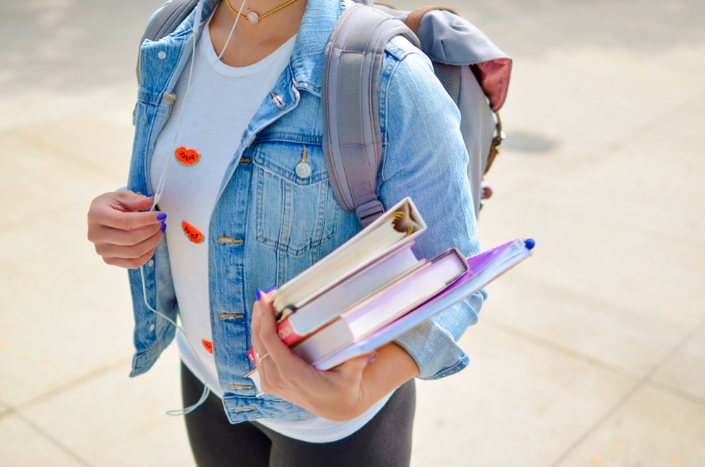 student carrying books and bag