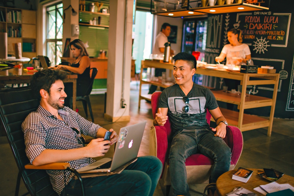 two men talking and sitting on a couch