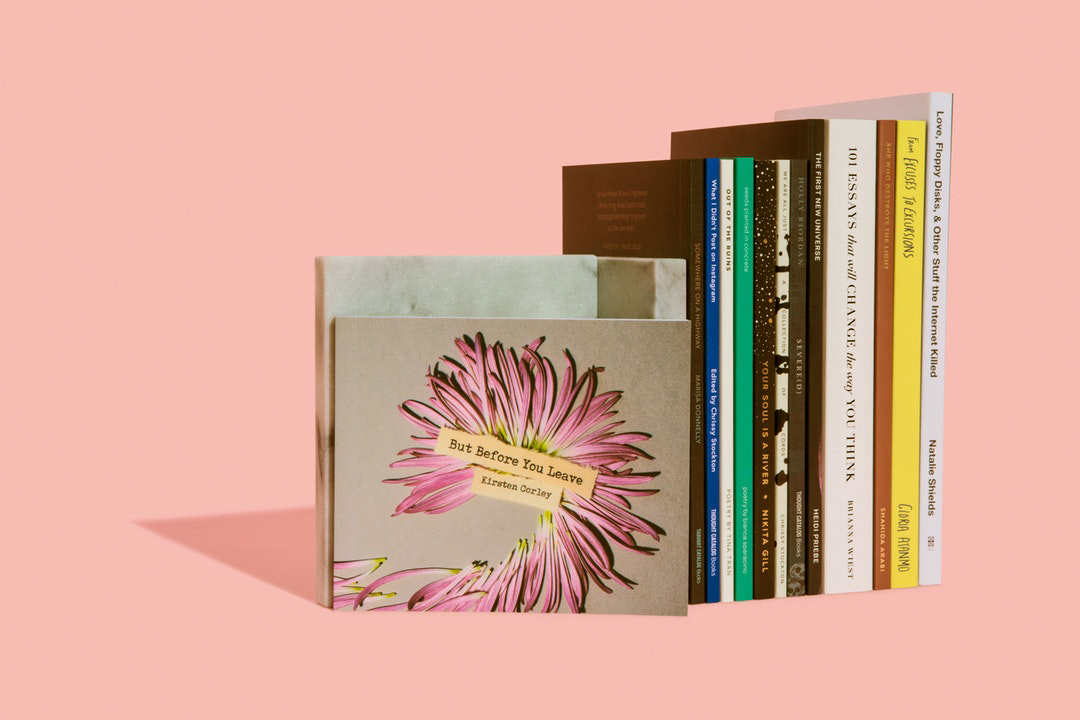 row of books against a pink background