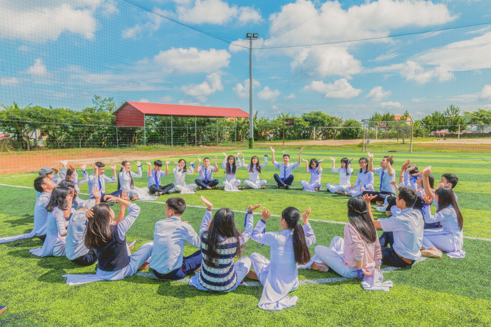 students sitting in a park forming a circle