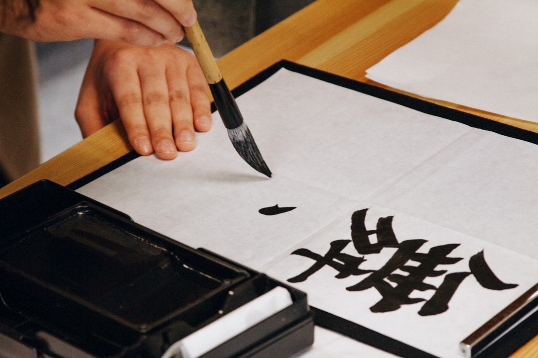 chinese characters being painted on a cloth
