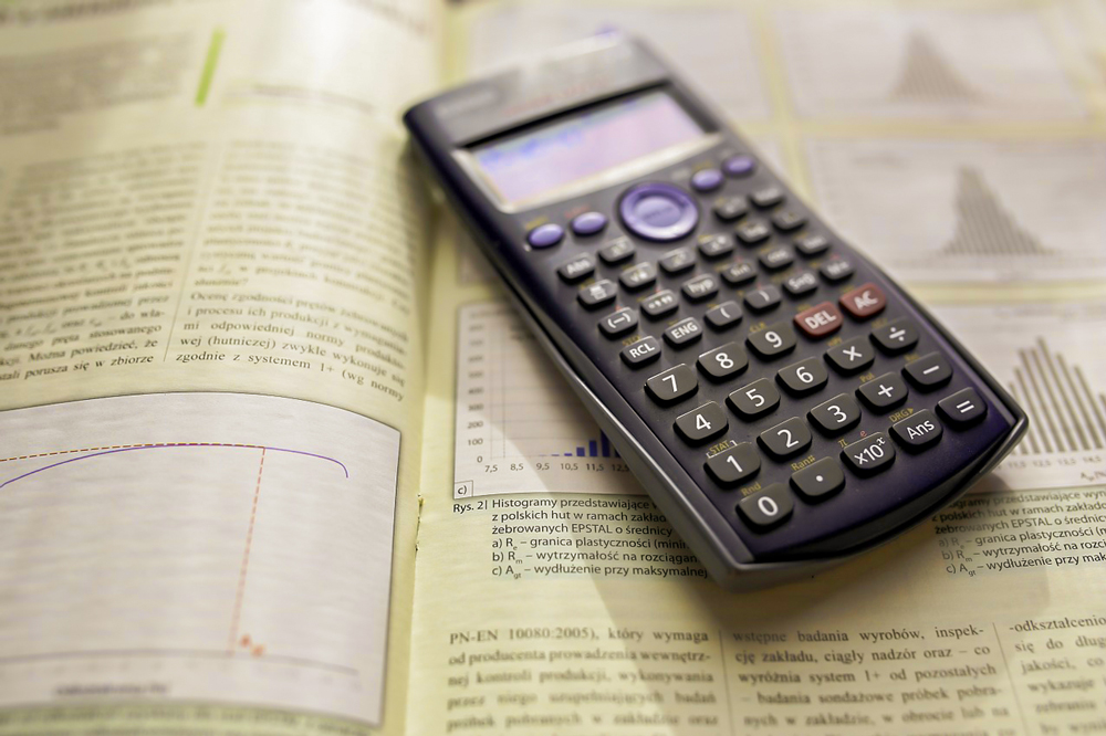 scientific calculator on top of open book showing graphs