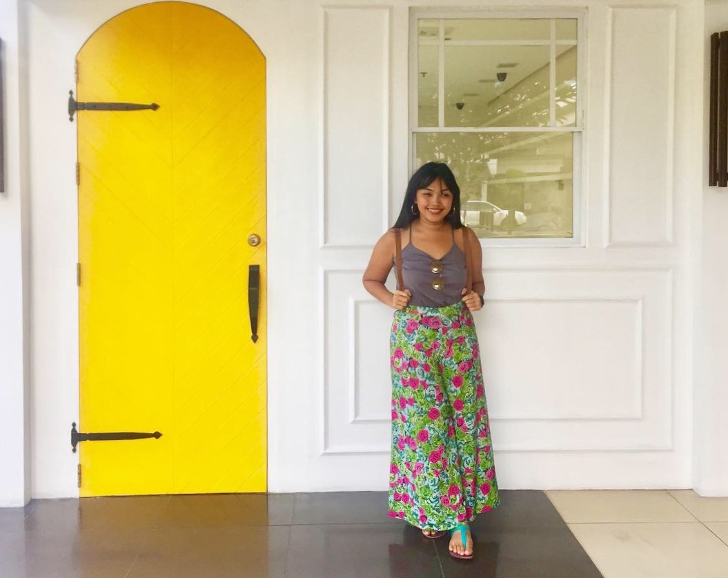 Technopreneur Meryl Jalani posing in front of white wall and yellow door