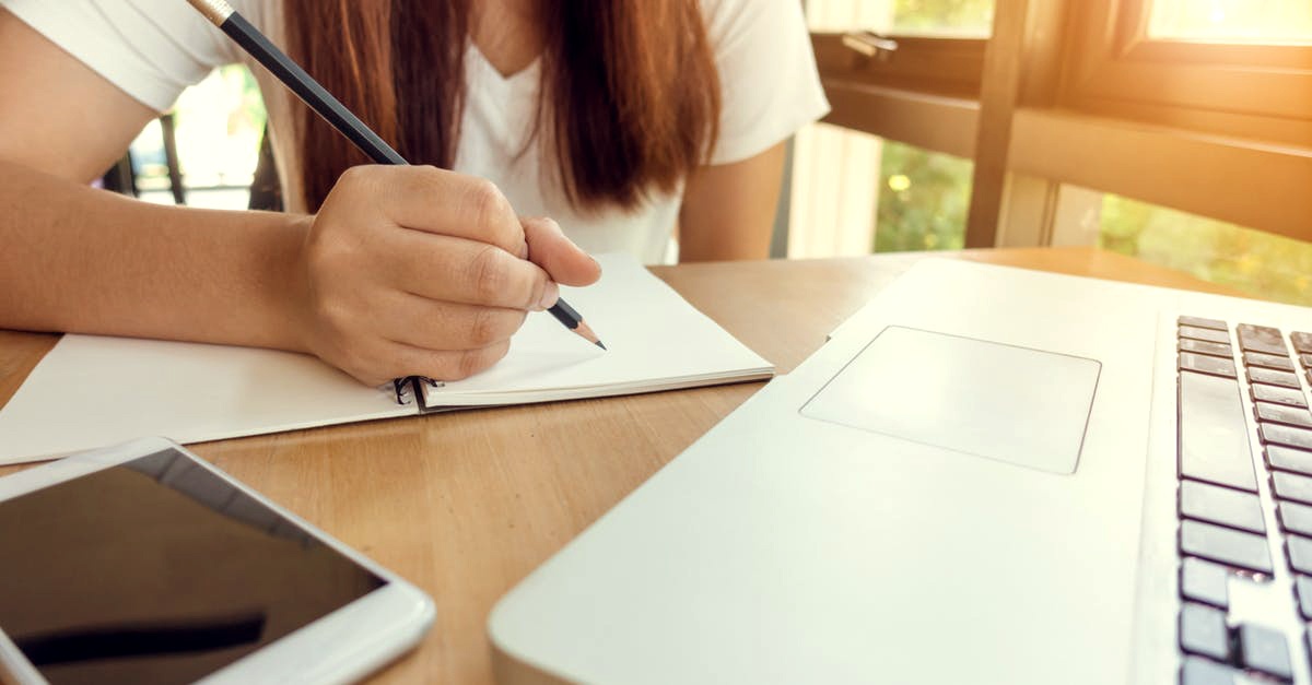 Woman holding a pencil and writing on paper