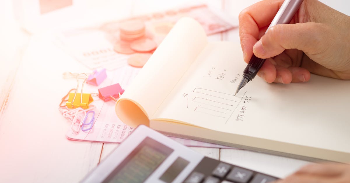 writing chart on piece of paper beside calculator
