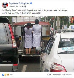Two women passengers hanging at the back of a jeepney