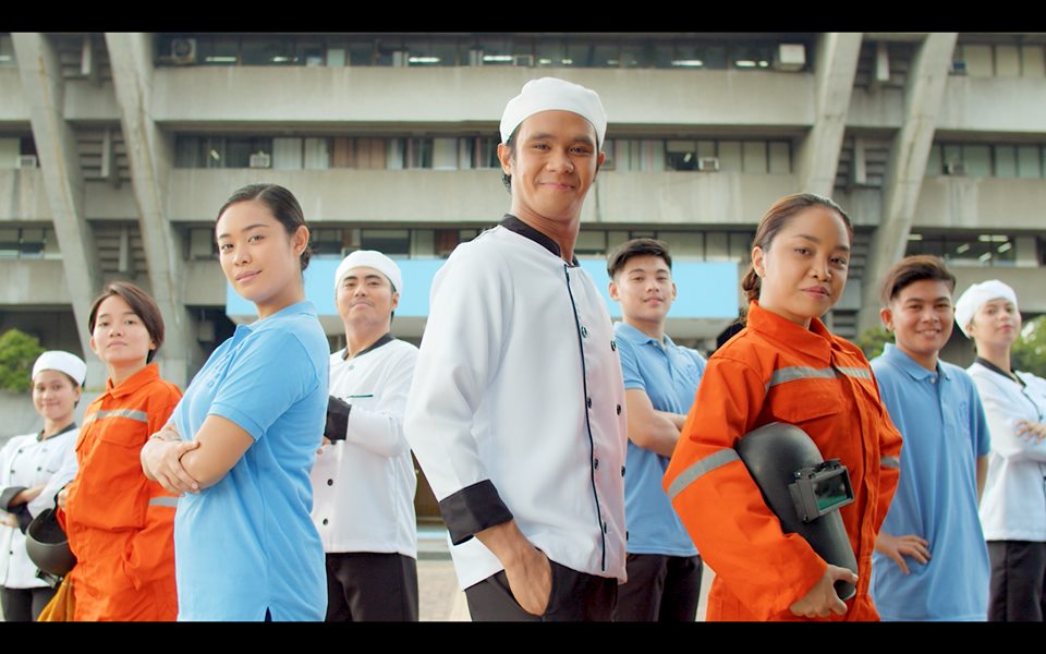 male and female welders, chefs, and other professionals proudly standing