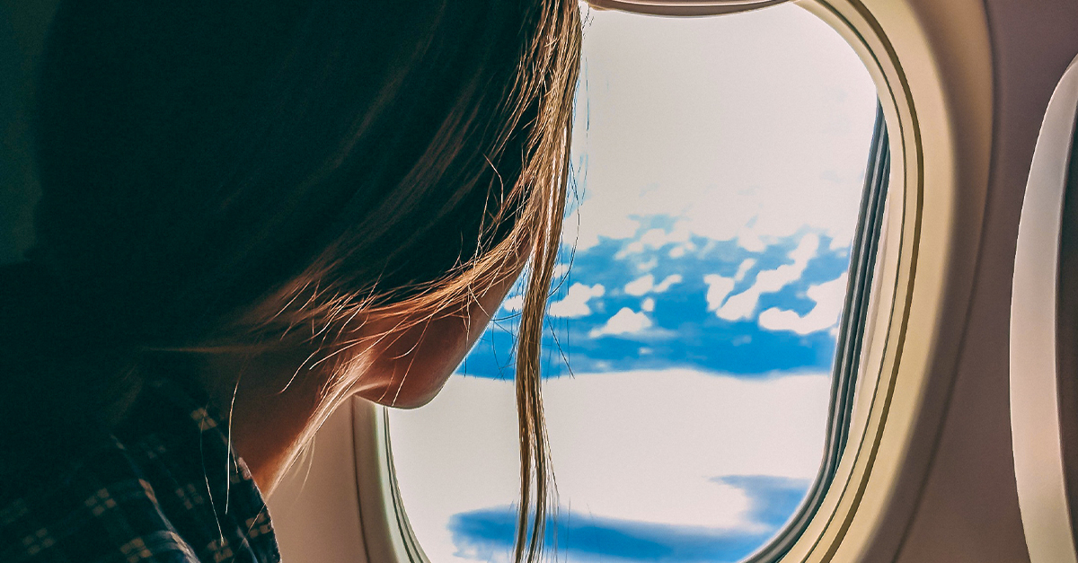 woman looking out of an airplane window