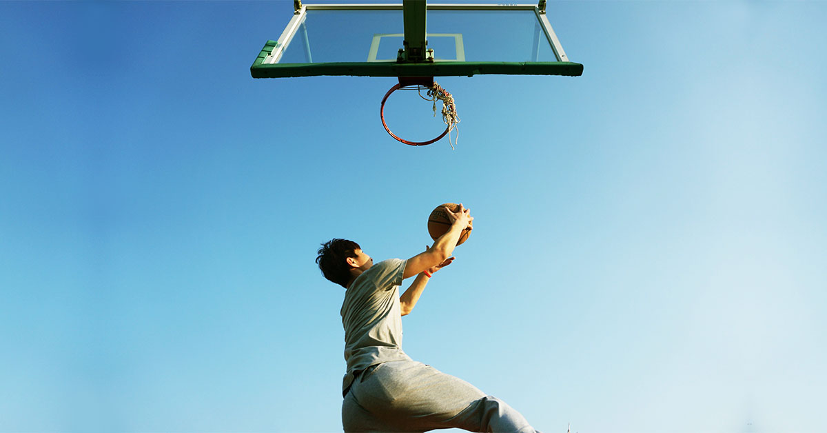 young man dunking a basketball in the ring