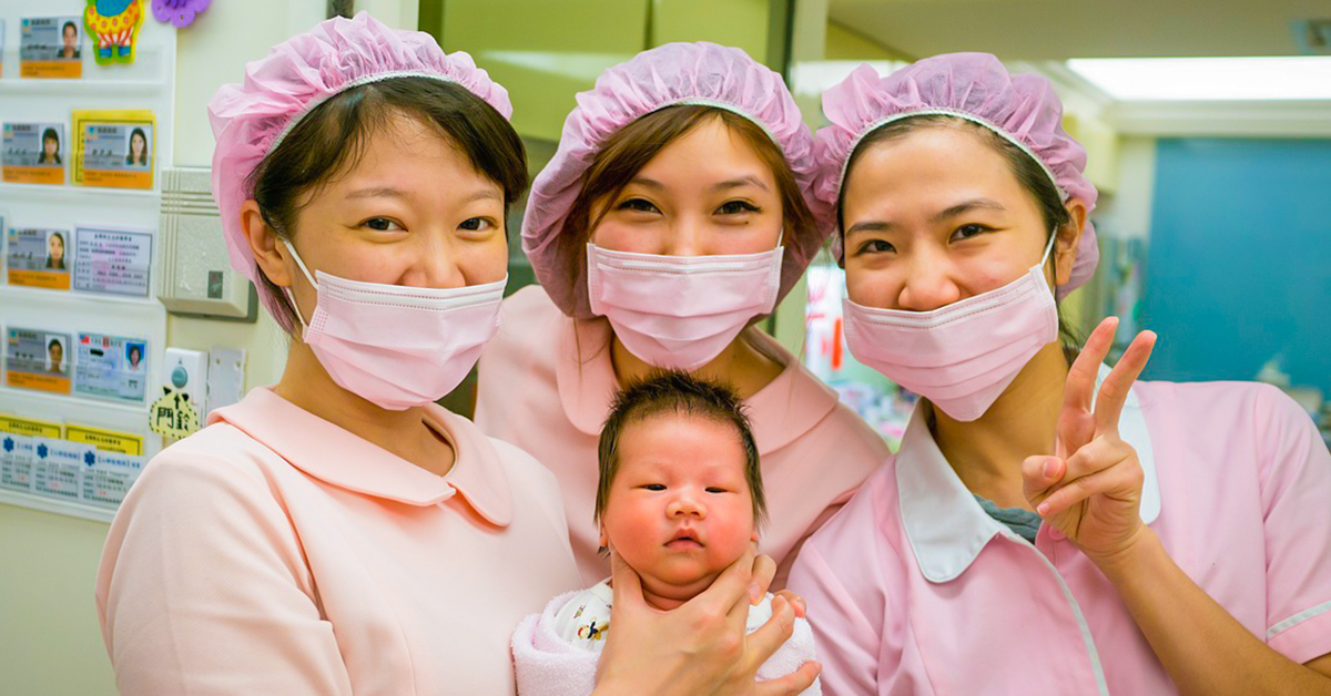 three nurses holding a baby