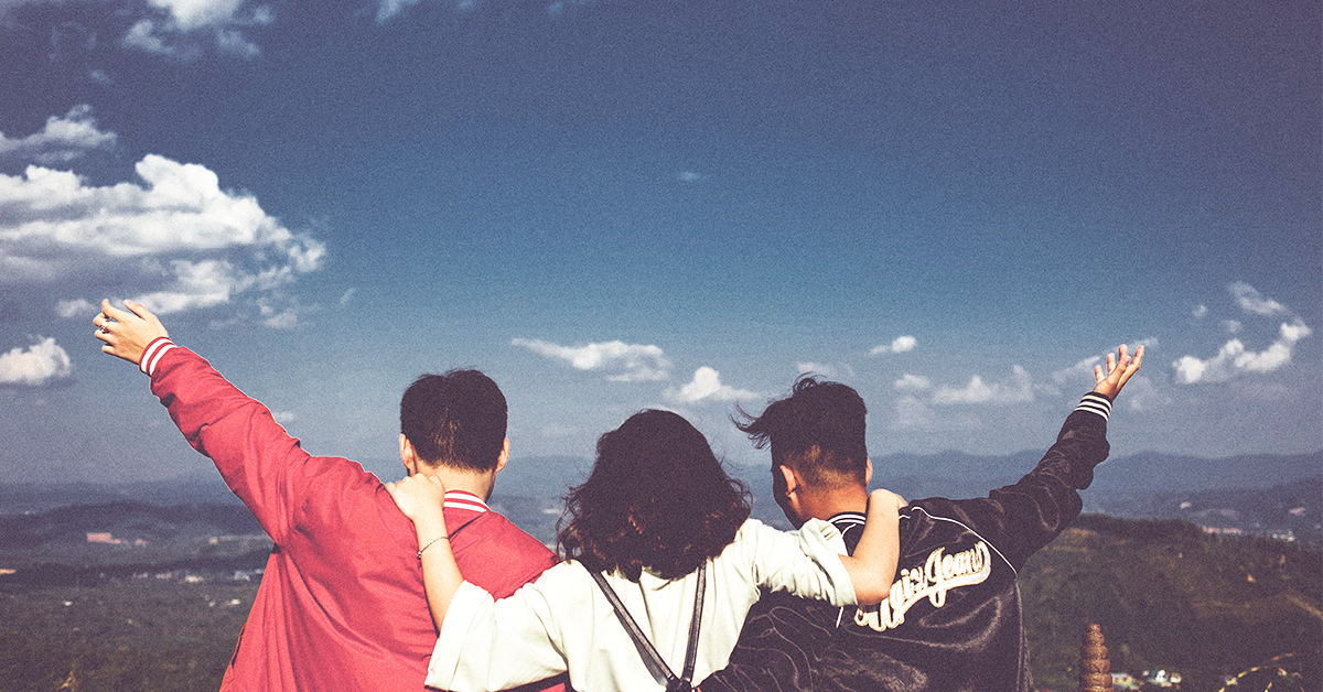 three friends looking out from a mountain view