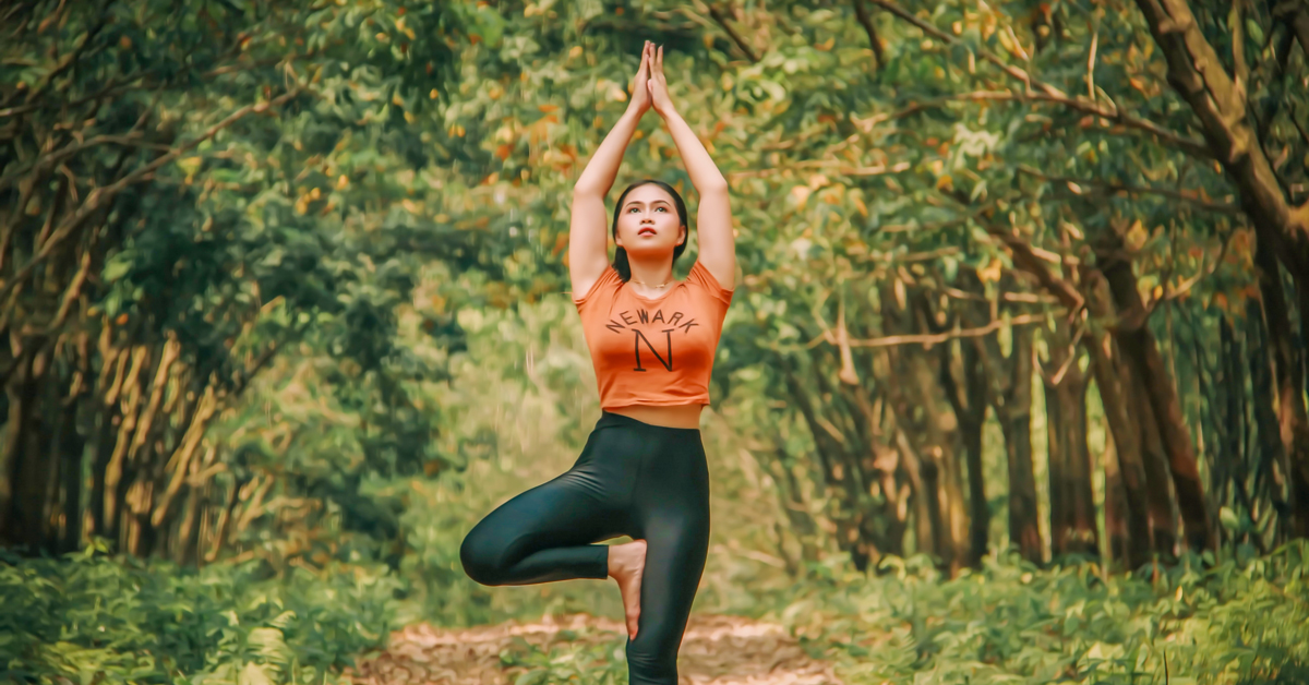 girl doing a yoga pose with arms raised and hands joined together