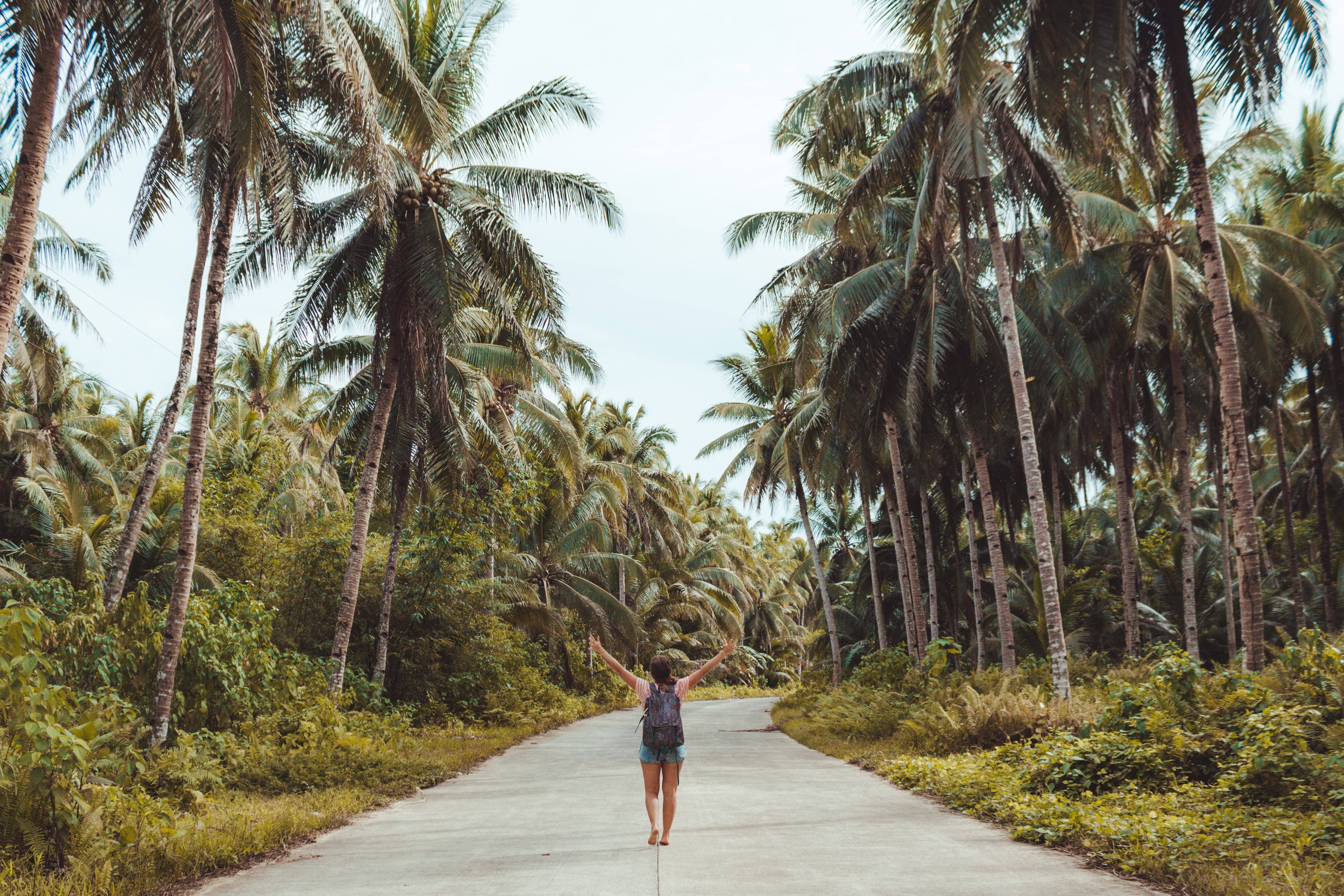 filipino culture and tradition of a woman walking down a road surrounded by trees