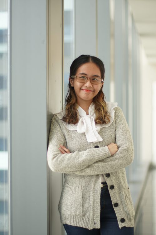 FTW scholar Meryle Almirañez smiling beside a window
