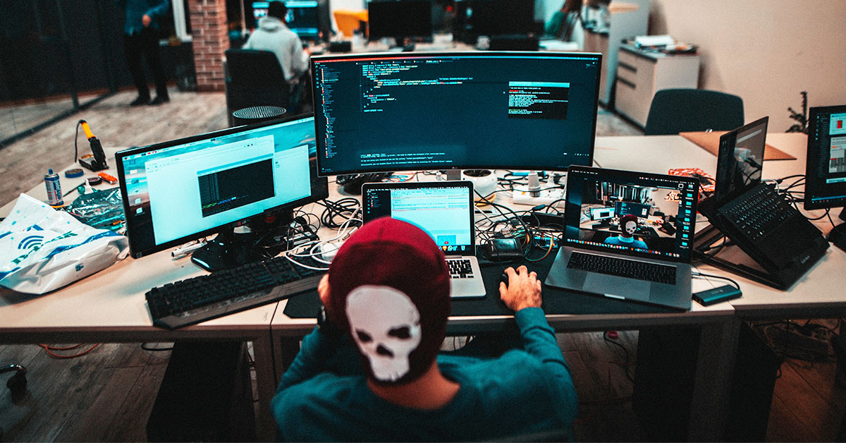 young man working in front of laptops and monitors