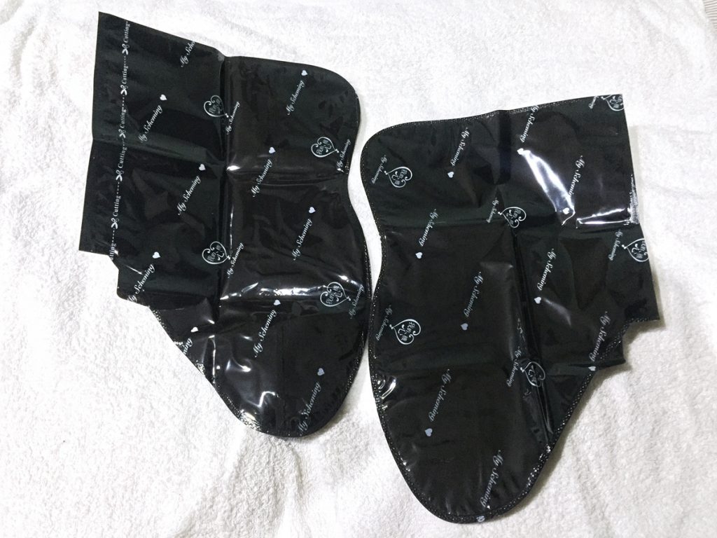 2. Unfold the mask, and you'll see two large plastic "sock" masks.
Cut along the top, following the dotted lines.