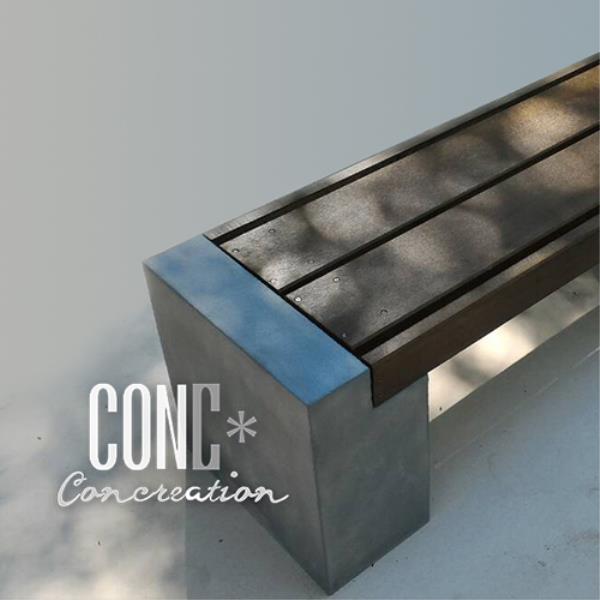 ฐานหล่อขี้นรูป​โทนสีเข้ม กับปูนเปลือยดิบๆ ร่วมกับระแนงไม้ที่ให้อารมณ์ของไม้หมอนรถไฟ ตัวที่นั่งทำจากไม้ไฟเบอร์ซีเมนต์ 