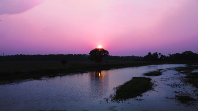 By the side of a canal fed with fertile water, the sun, having finished his duty, leaves to take a little rest.