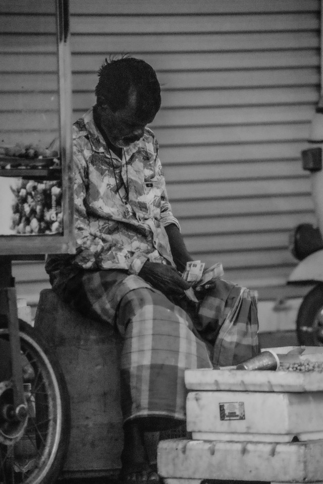 A old seller counting  money he earned in a day