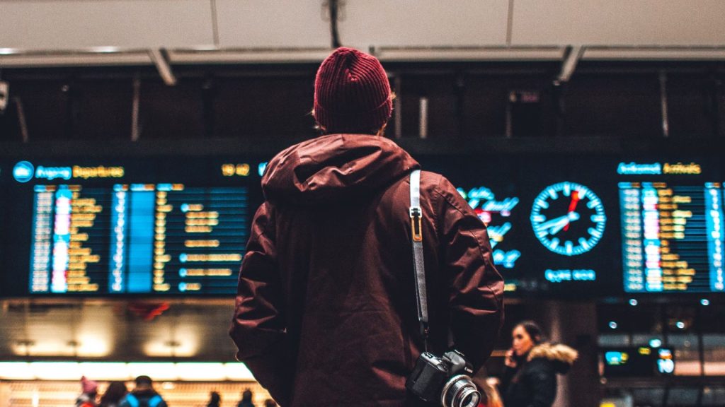 Traveller looking at the departures board in an airport.