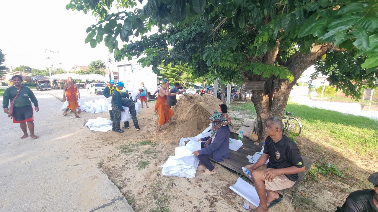 พระสงฆ์ ชาวบ้าน ทหาร ช่วยกันตั้งแนวกระสอบกั้นน้ำเข้าวัดโคกหิรัญ