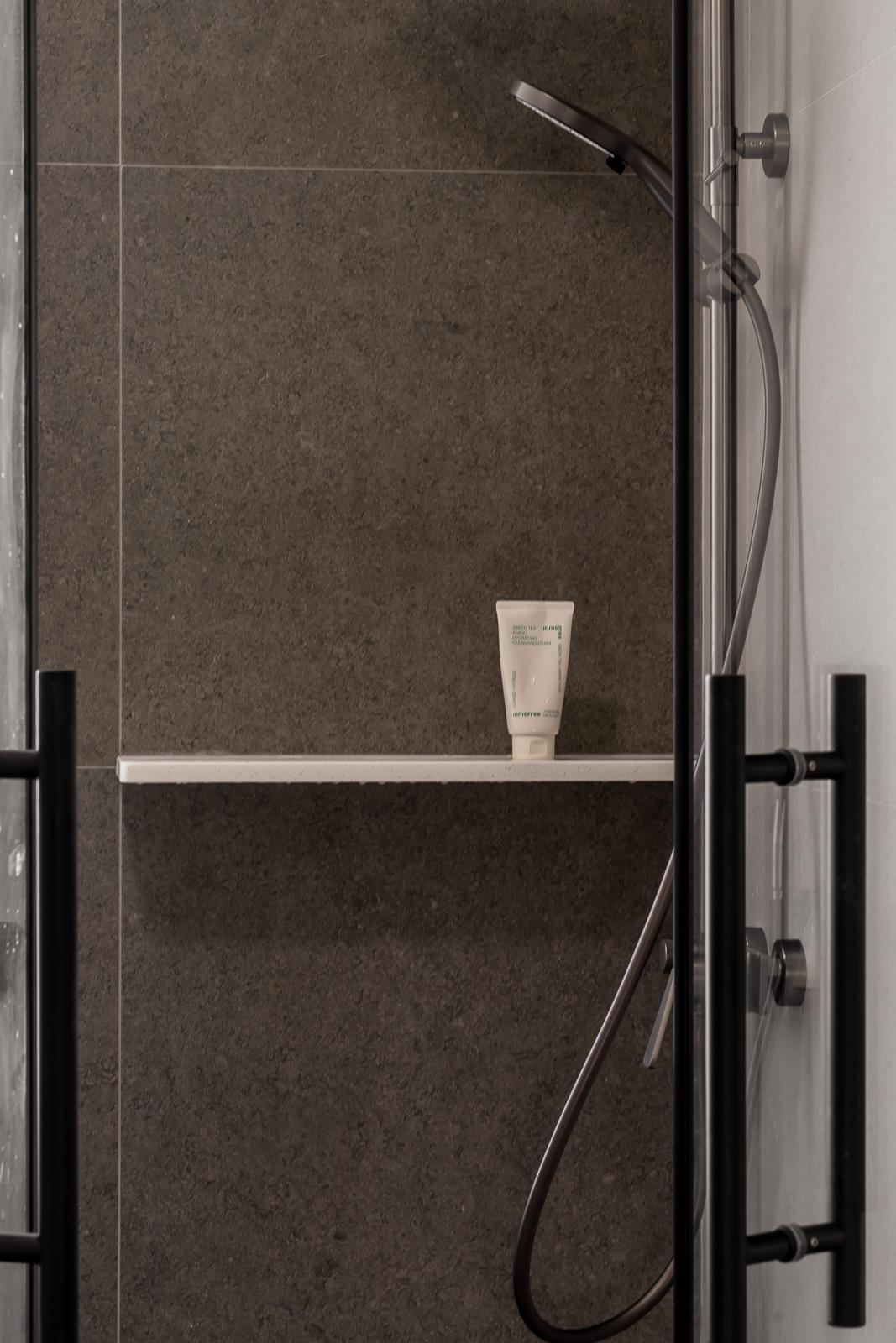 Modern Bathroom with Homogeneous Tiles and Rainshower