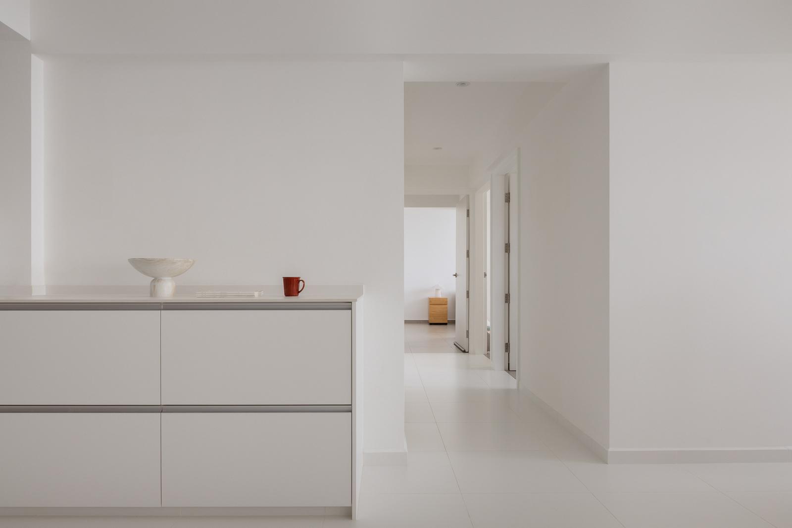 Minimalist Hallway with Homogeneous Tiles and Storage Cabinets