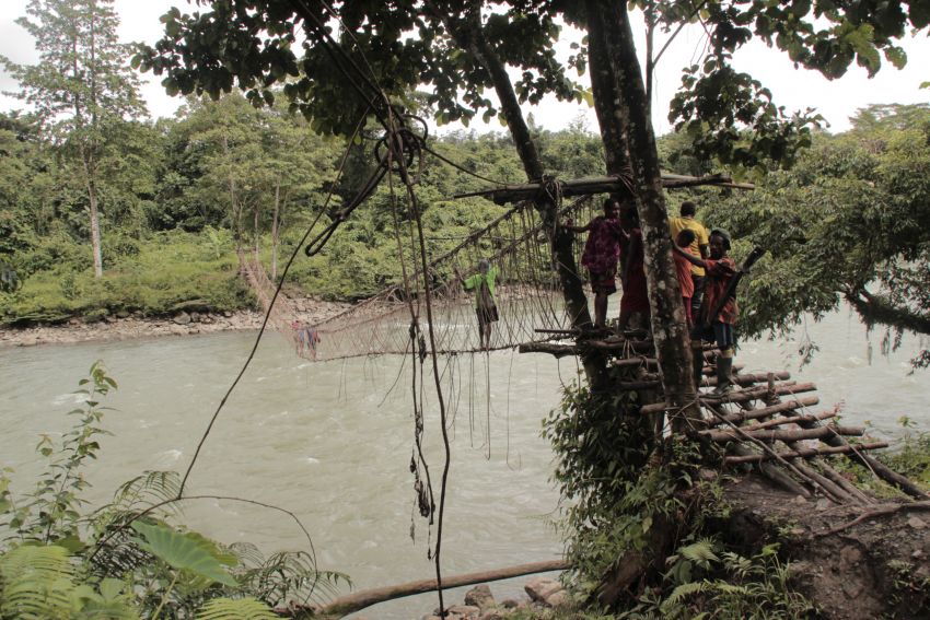 Siswa yang sedang pergi ke kota melewati jembatan rotan